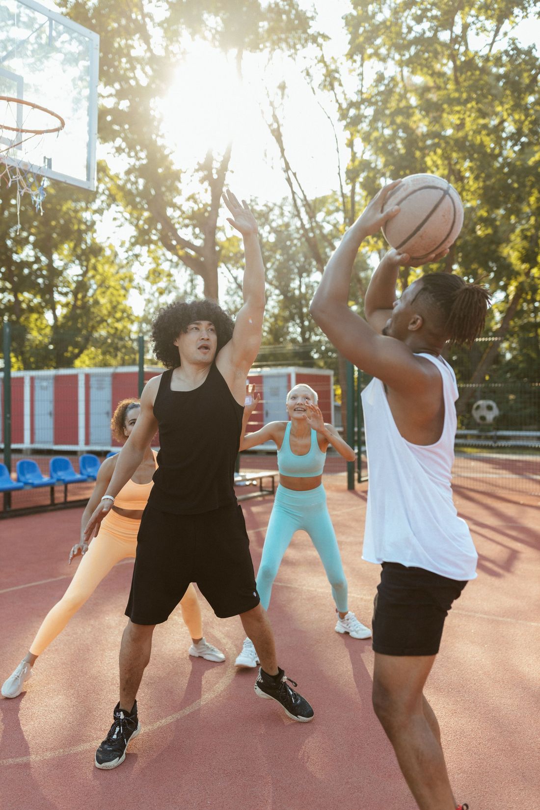 A group of friends playing a pickup basketball game at an outdoor court