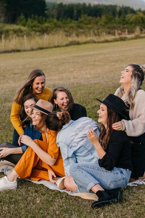 Friends laughing together on a picnic blanket